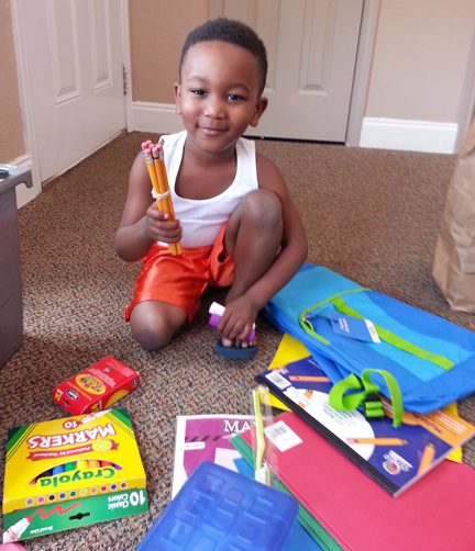 A young student receives school supplies from your gifts to and through Mission Arlington!