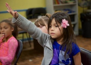 A young girl asks her Bible study teacher a question at an after-school program in central Arlington