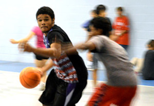 Driving to the basket at a Mission Arlington youth gym night.